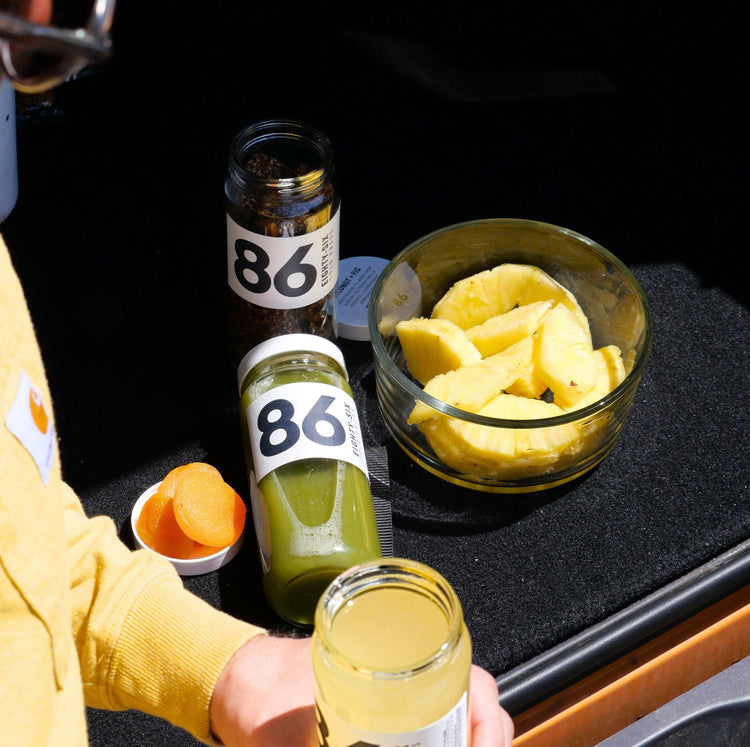 Snacking on a trip to Colorado with pineapple, Energy Nugs, cold-pressed juice, and dried apricots as part of a balanced wellness routine.